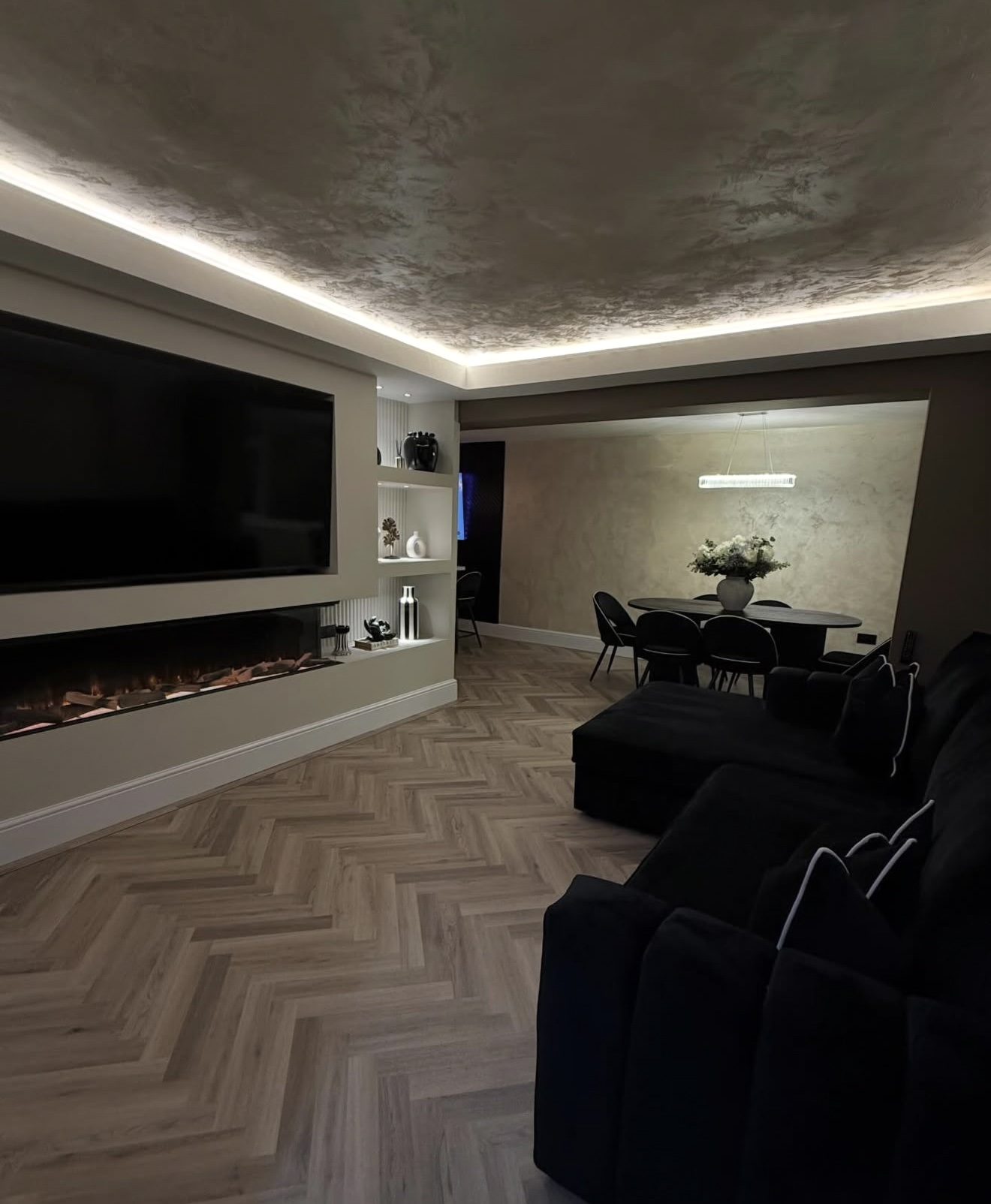 Lounge with media wall and fire over natural oak herringbone